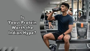 A man in gym clothes drinking from a black shaker bottle labeled "Yeast Protein" while seated on a gym bench, with a bag of yeast protein powder beside him and text reading "Is Yeast Protein Worth the Indian Hype?"